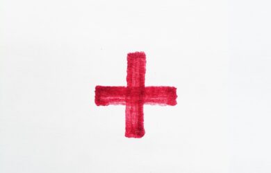 a red cross painted on a white paper